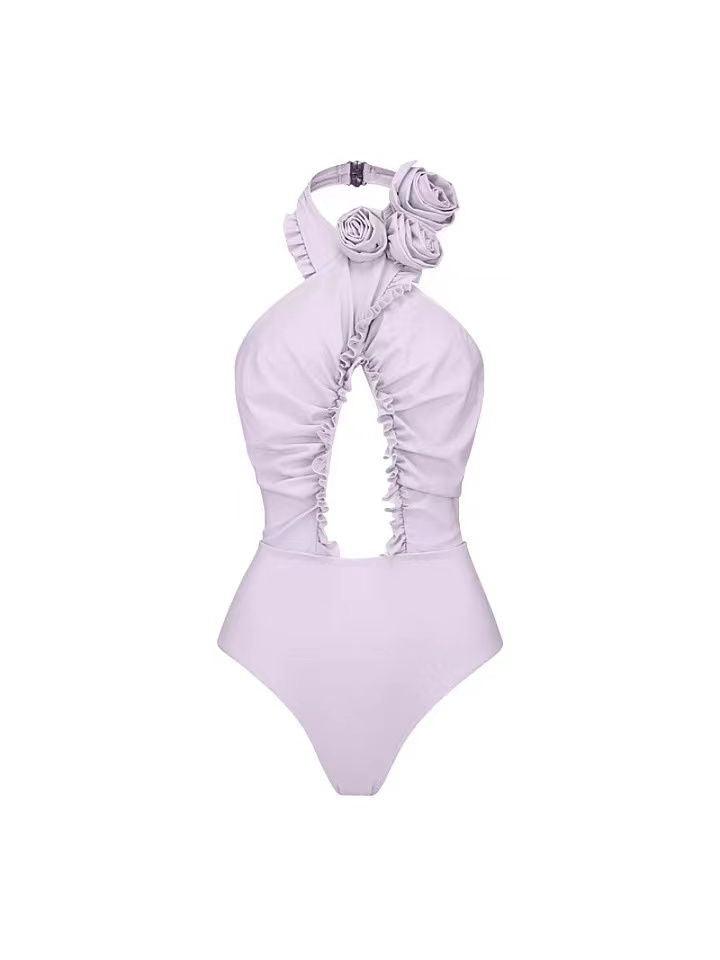 Lavender halter-neck one-piece swimsuit with three large 3D flower appliques at the shoulder and ruched front panels.