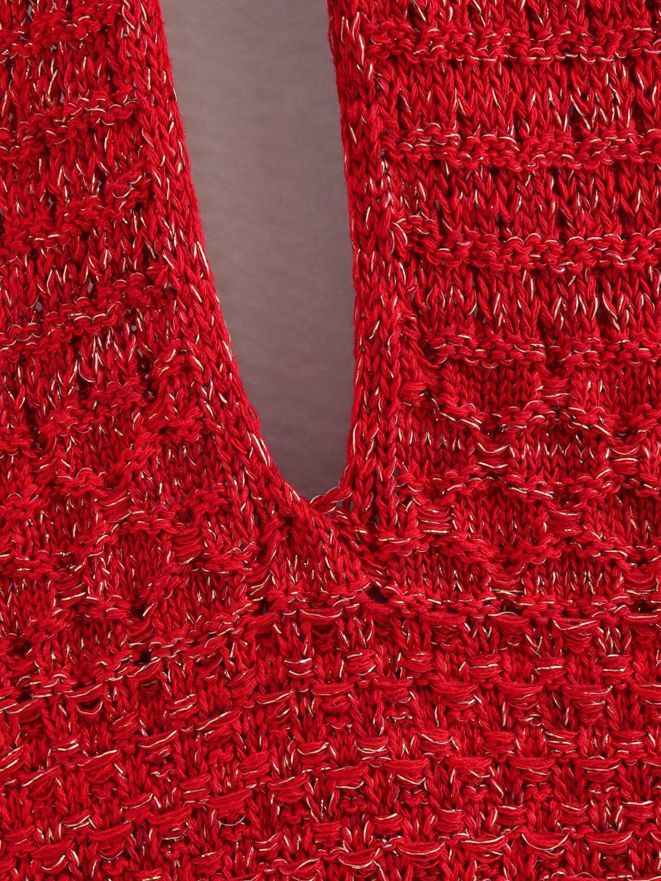 Close-up of red knitted fabric with gold metallic threads, showing a deep V neckline formed by overlapping panels.