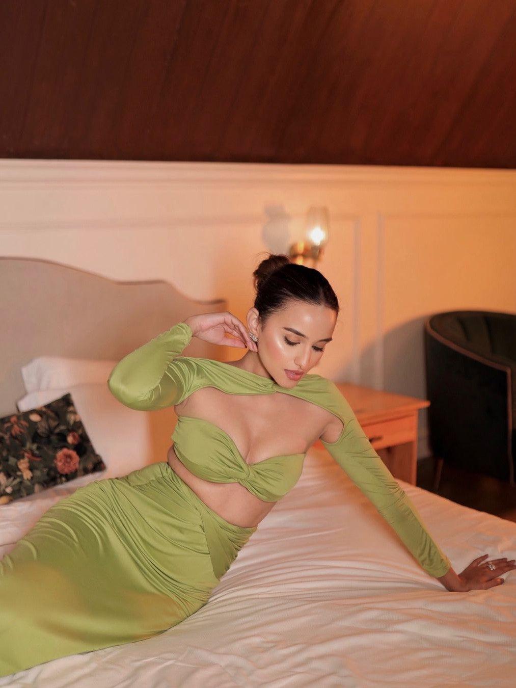 Lime green bandeau tube-top with long sleeves and matching ruched skirt coord set, model lounging on bed.