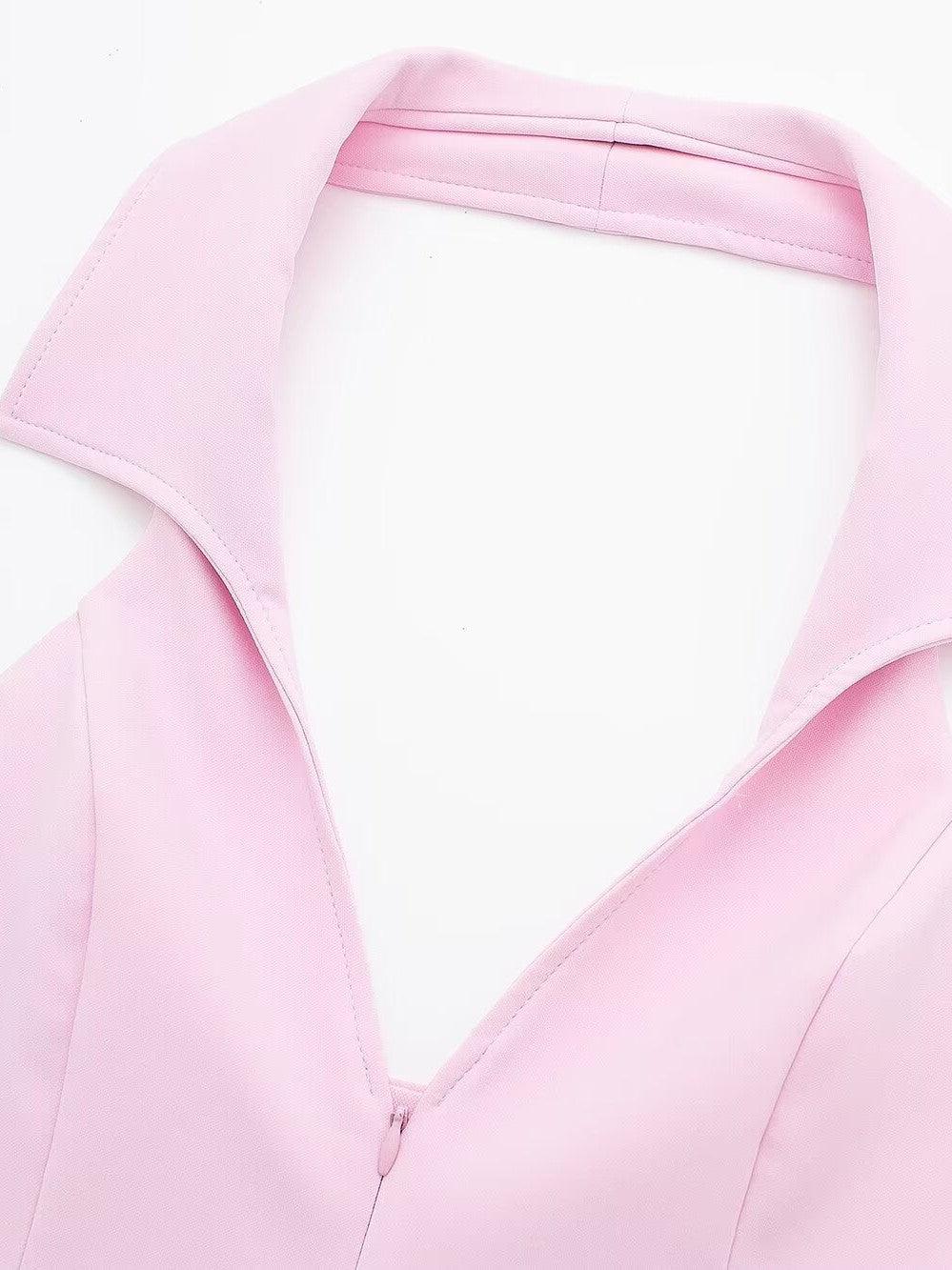 Close-up of pale pink halterneck waistcoat showing wide, folded lapels and a center back zipper.