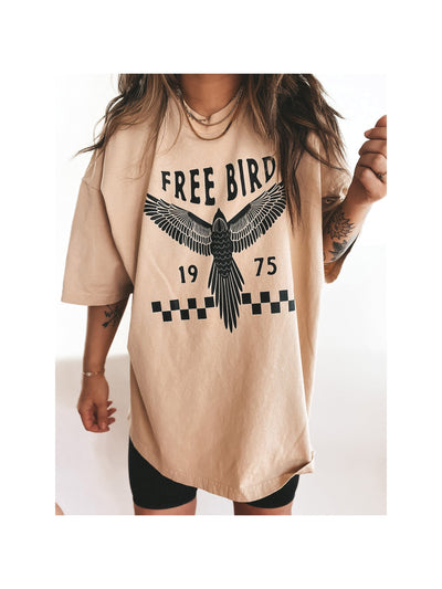 Beige oversized T-shirt dress with a black FREE BIRD print: a soaring bird, checkerboard stripe, and numbers 19 and 75.