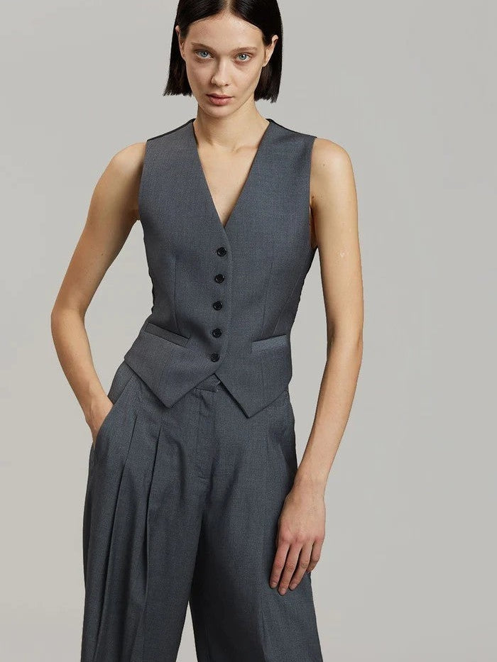 Charcoal gray sleeveless waistcoat with five buttons, paired with matching high-waisted pleated wide-leg pants.