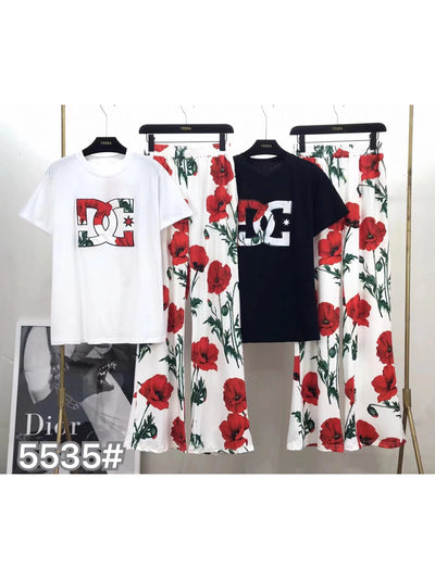 White and black T-shirts with floral logo, paired with white wide-leg pants printed with red flowers and green stems.