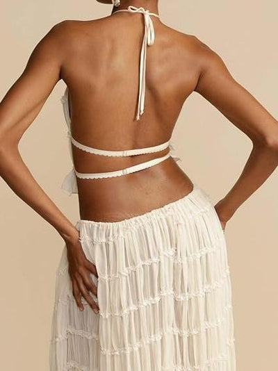 Back view of a model in ivory Cloud Ruffle Halter Co-ord Set with halter neck, wrap straps, and sheer ruffle skirt.