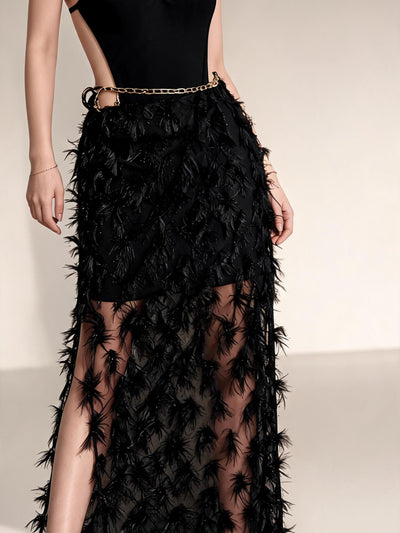 Noir chain-link halter monokini with feathered black skirt overlay and gold chain belt