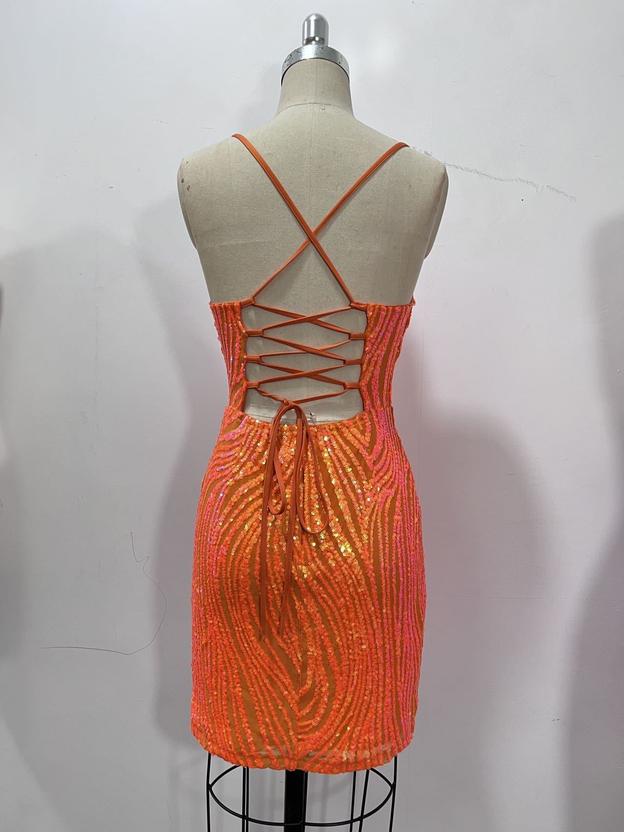 Back view of coral-orange sequin mini dress with crisscross lace-up corset back and long back tie.