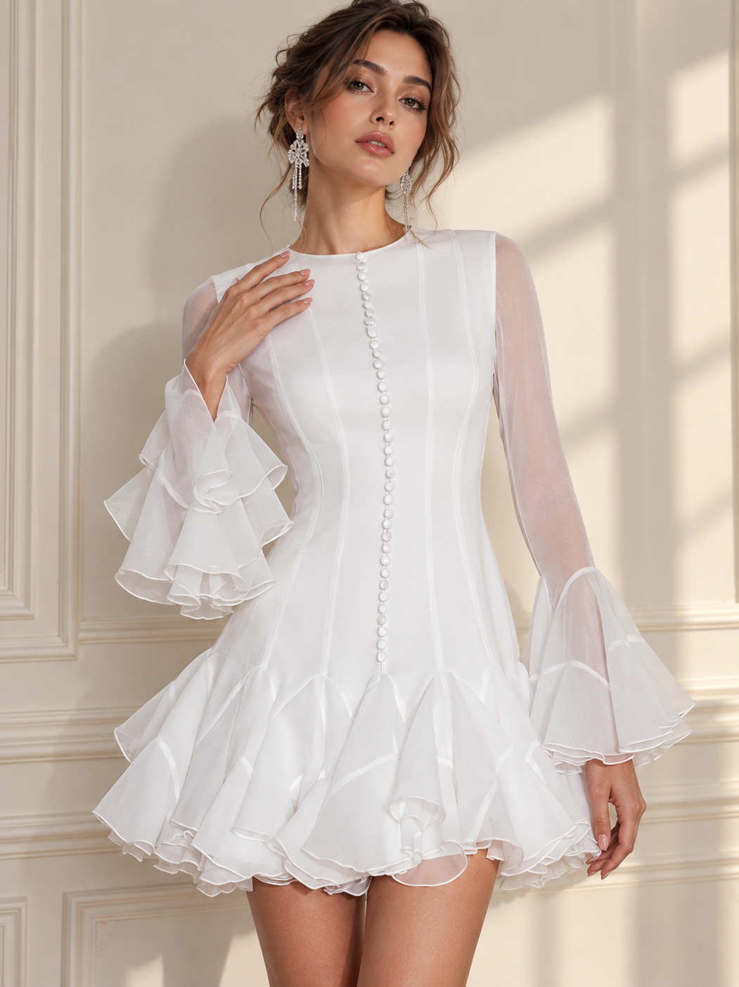 Elodie Blush Mini Dress by EXCLUSIVES; white satin-like, sheer long sleeves, pearl button front, tiered ruffle hem.