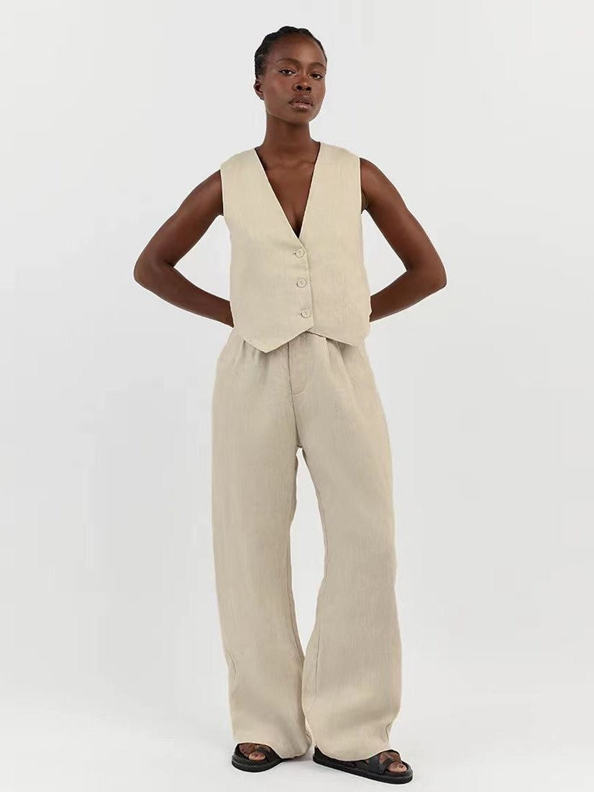 Beige sleeveless waistcoat vest with three buttons over matching wide-leg linen pants; V-neck, relaxed fit.