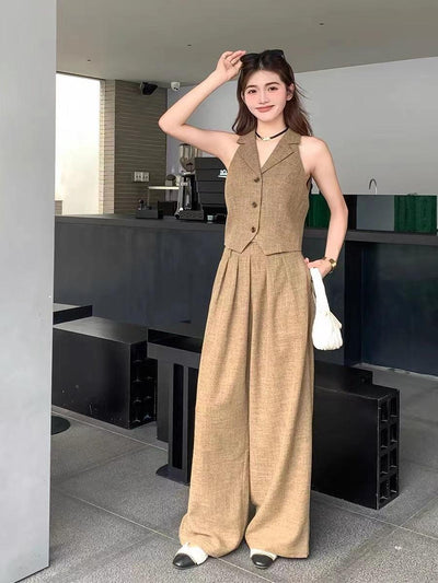 Beige cropped waistcoat with matching wide-leg pants coord set, linen-look texture, model holds white bag at cafe.