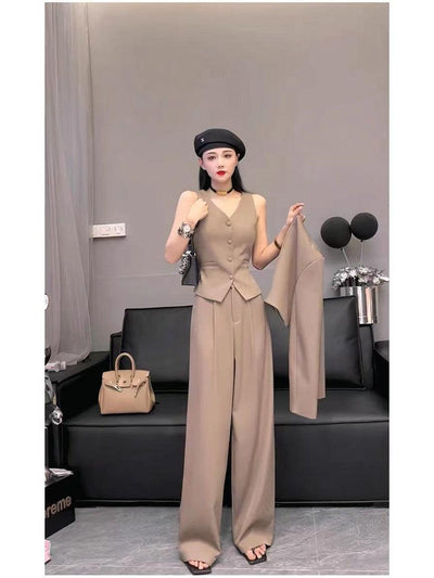 Beige waistcoat vest with matching wide-leg pants, model holding a blazer; black beret, choker, beige handbag nearby.