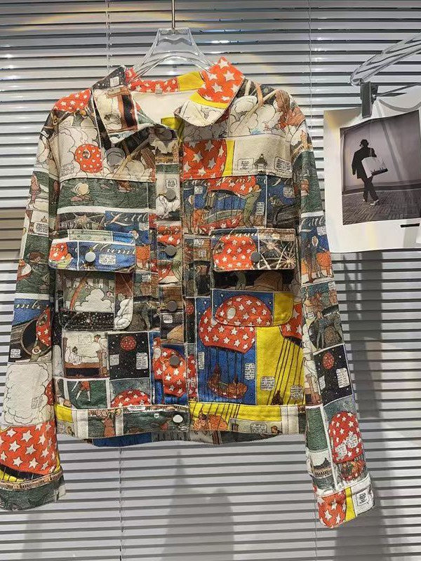 Brown patchwork denim jacket with comic-panel prints, red star blocks, front pockets, metal buttons, on a hanger.