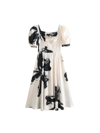 Cream midi dress with bold black brush print, corset-style bodice, and voluminous puff sleeves.