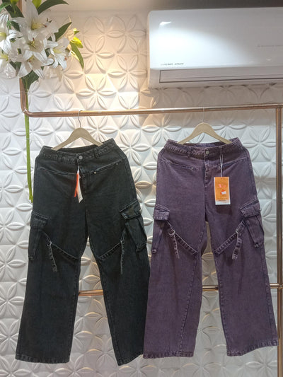 Two cargo denim pants in dark and purple, wide-leg high-waist with side pockets and strap ties, on a copper rack.