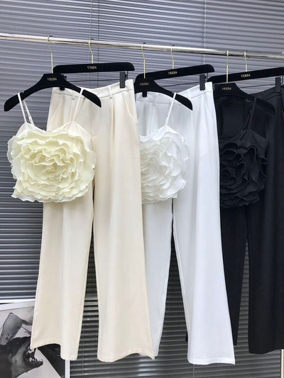 Coord set on hangers with cami crop top and straight pants, featuring a large layered flower applique.