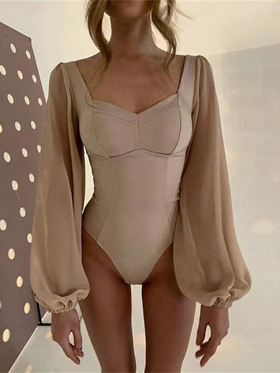 Beige patchwork mesh long-sleeve bodysuit with sheer puff sleeves and a structured sweetheart bust.