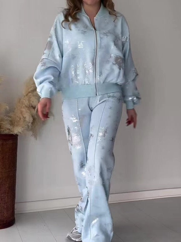 Light blue metallic patch coord set: zip jacket with ribbed cuffs and waistband, matching pants with silver patches.