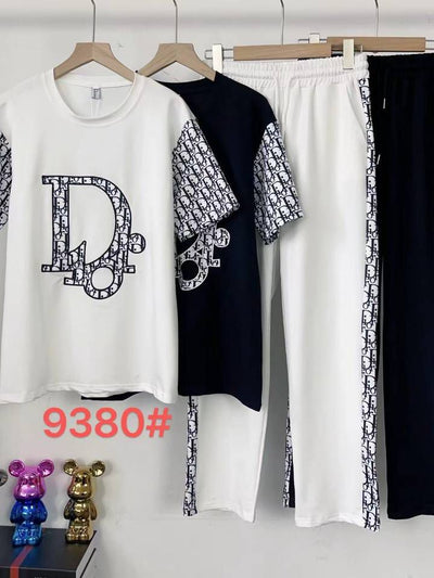 White tee with D monogram and patterned sleeves; navy tee with patterned sleeves; white pants with side patterned stripe