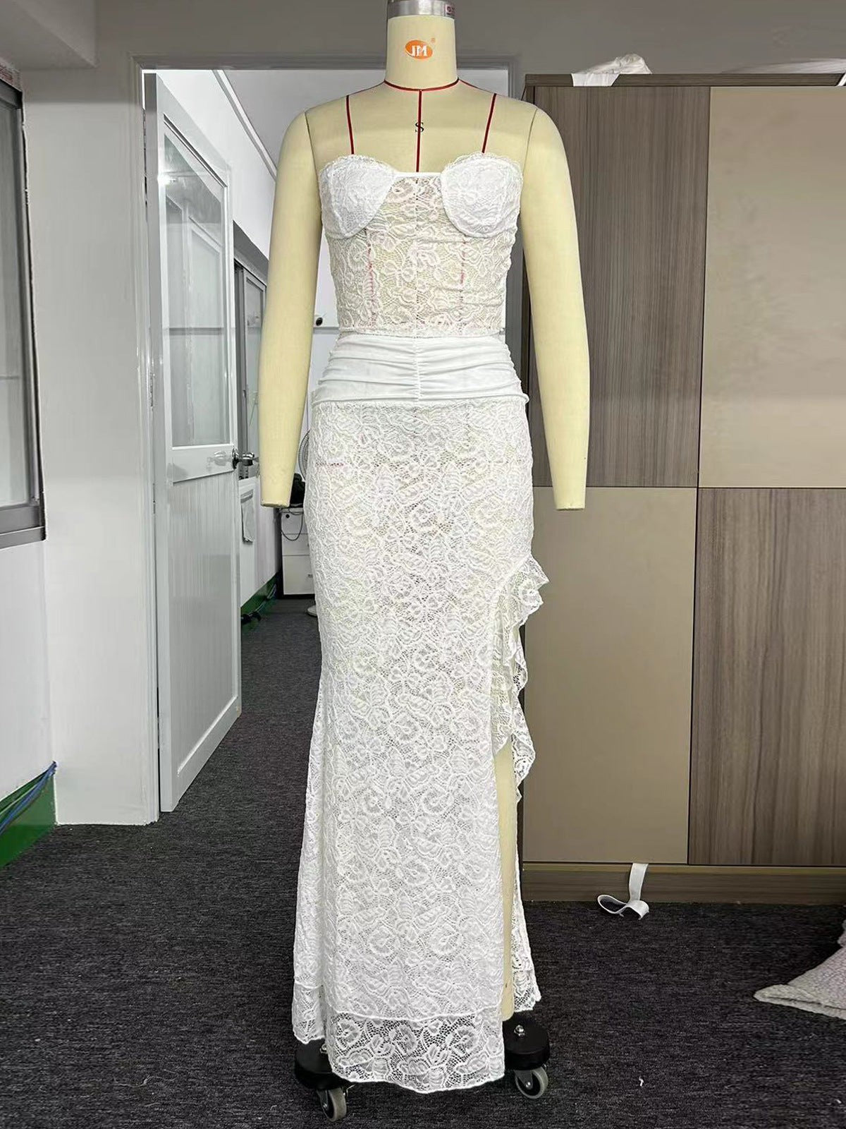 White lace two-piece on dress form: strapless tube top, ruched waist, long skirt with irregular side slit.
