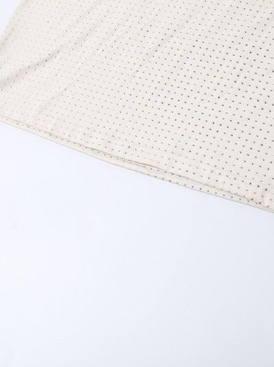 Cream fabric with tiny black dotted pattern and a visible stitched hem along the edge.