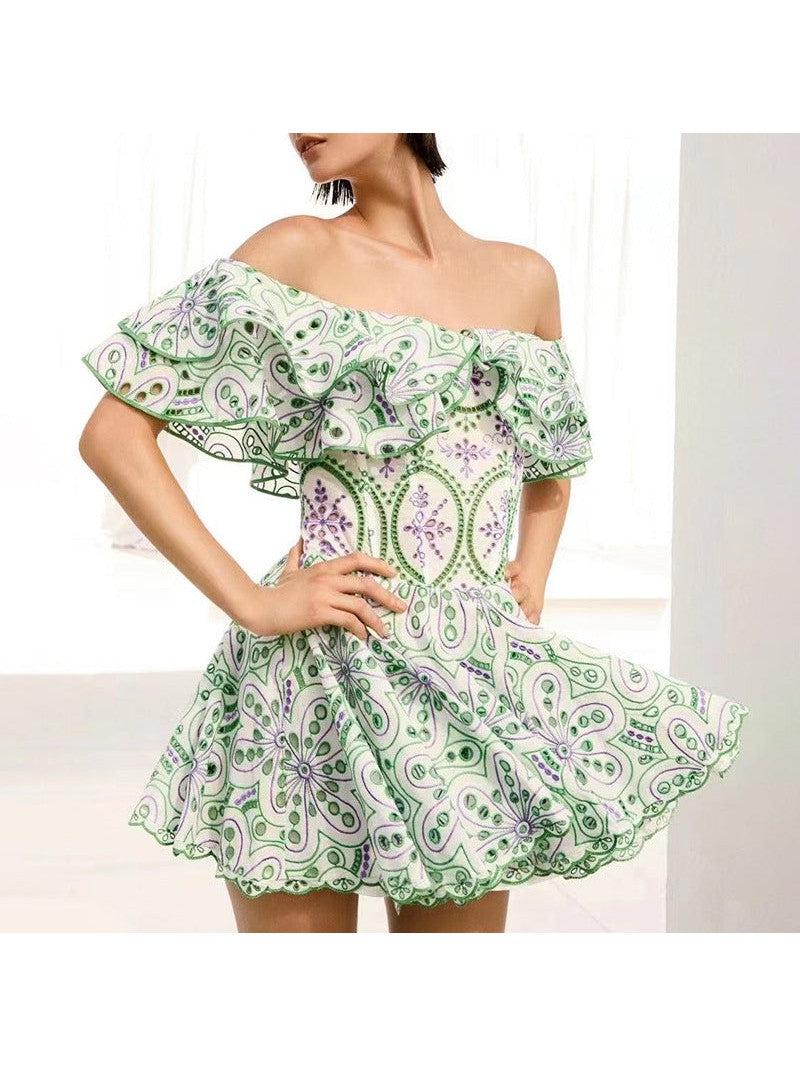 Off-shoulder white dress with green and purple embroidered paisley pattern, wide ruffled neckline, and short flared skirt.
