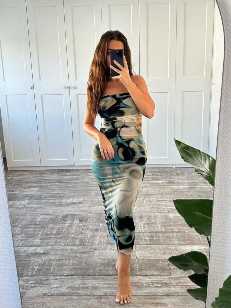 Full-length mirror selfie of a woman wearing a strapless beige-tie-dye patch print tube dress, midi length, standing barefoot.