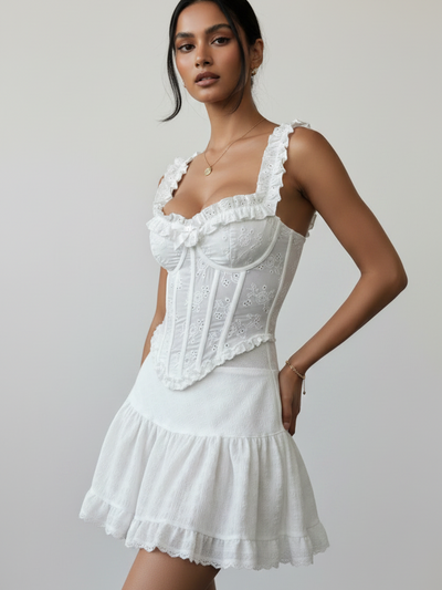 White eyelet lace-up corset top by Exclusives, featuring floral embroidery and ruffled straps