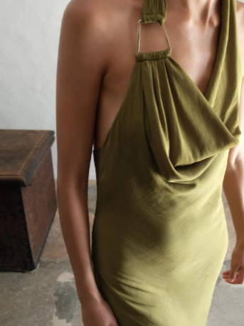 Olive-green satin-blend halter dress with a draped cowl neckline and slim neck straps, worn by a model.
