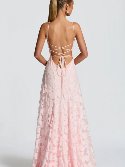 Back view of a pale pink floral-appliqué maxi dress with spaghetti straps and a crisscross lace-up back.