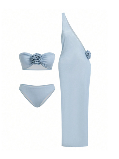 Ice blue three-piece swim set: bandeau top with flower, matching bottoms, and one-shoulder cover-up with side flower.