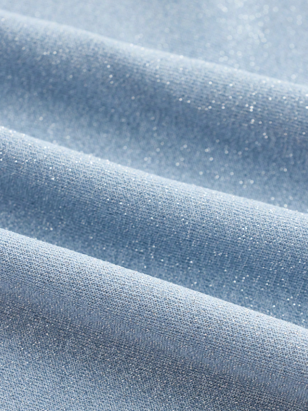 Close-up of ice-blue fabric with tiny sparkles and soft, wavy folds.