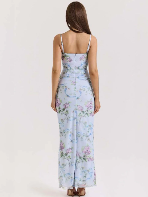 Back view of a woman wearing a sky-blue floral ruched spaghetti-strap maxi dress with a flowing printed skirt.
