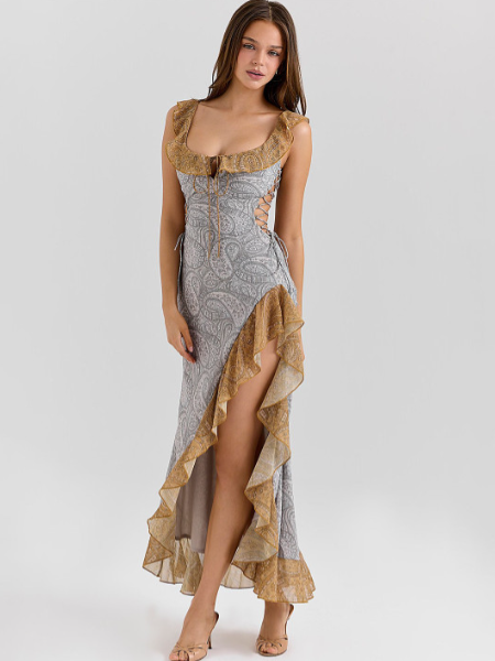 Model wearing grey paisley off-shoulder maxi dress with gold ruffle trim, side lattice cutouts, and a high-low hem.