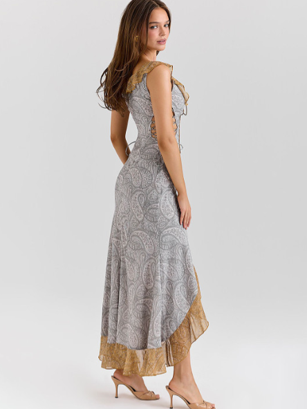 Model in gray paisley off-shoulder ruffle maxi dress with beige lace hem and high-low silhouette.