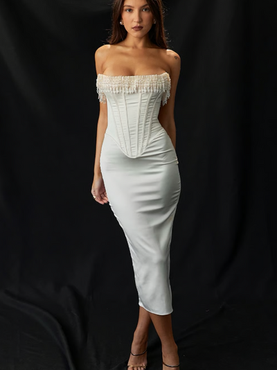 White strapless corset midi dress with pearl fringe neckline and boned bodice, fitted silhouette on a model.