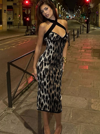 Abstract leopard print halter neck cross-strap bodycon maxi dress on city street at night, nude heels.