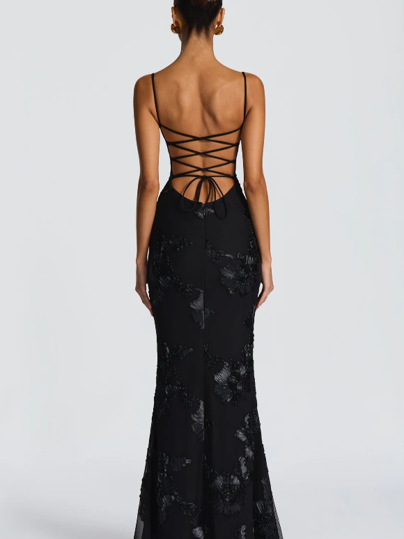 Back view of black floral jacquard mermaid maxi dress with thin straps, crisscross lace-up back and bow ties