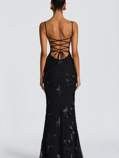 Back view of black floral jacquard mermaid maxi dress with thin straps, crisscross lace-up back and bow ties