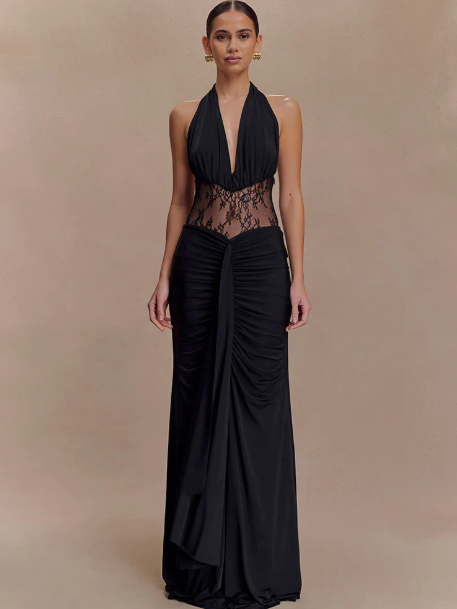 Model in black halter-neck maxi dress with sheer lace waist, deep plunge neckline, and ruched draped skirt.
