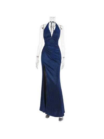 Navy blue shimmering backless halter maxi dress on a mannequin, plunging neckline, ruched waist, high slit.