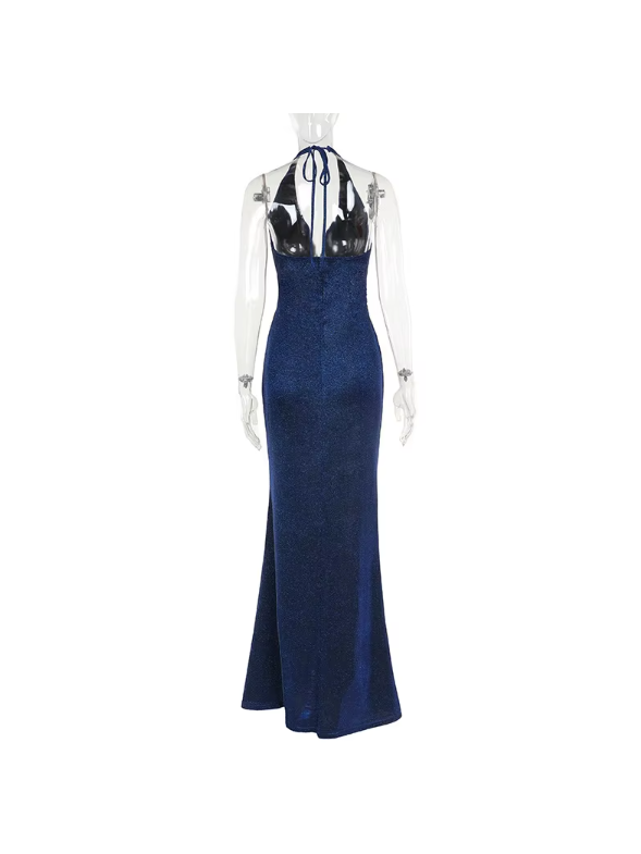 Navy shimmering backless halter-neck maxi dress with sheer long sleeves and a high slit on a mannequin.