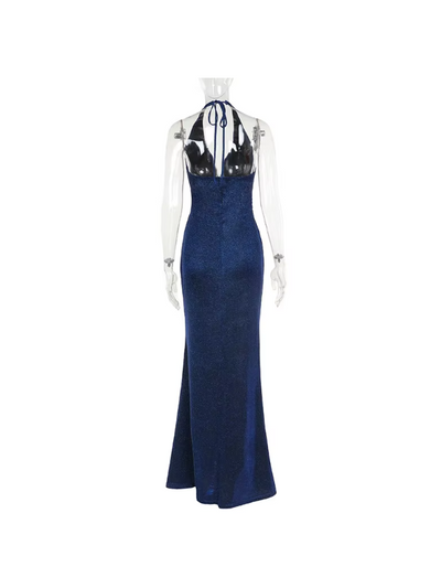 Navy shimmering backless halter-neck maxi dress with sheer long sleeves and a high slit on a mannequin.