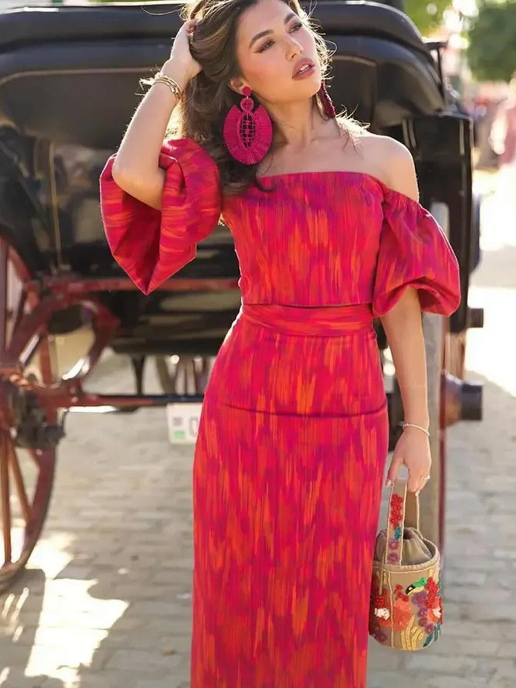 Model in a bright pink-orange printed off-shoulder puff-sleeve cami top with a matching high-waisted maxi skirt.
