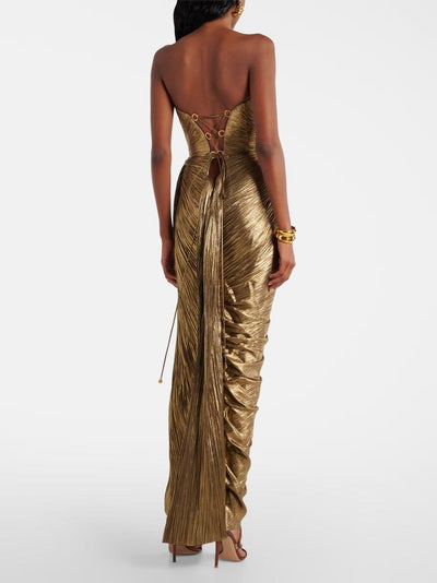 Back view of gold metallic pleated strapless maxi dress with lace-up back, gold rings, and long hanging ties.