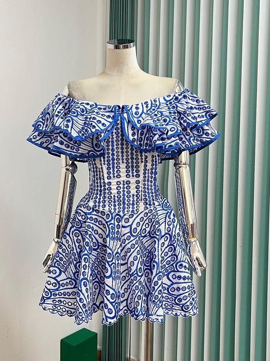 Blue and white off-shoulder embroidered cotton dress with layered ruffle neckline, fitted bodice, and flared mini skirt.