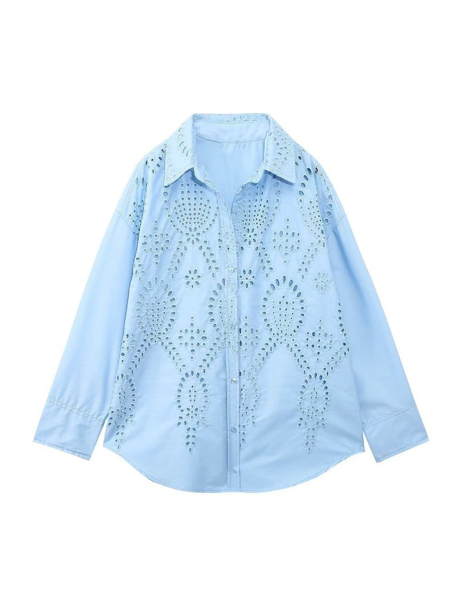 Light blue cotton shirt with allover eyelet floral cutouts, collared neckline, button-down front, long sleeves, curved hem.