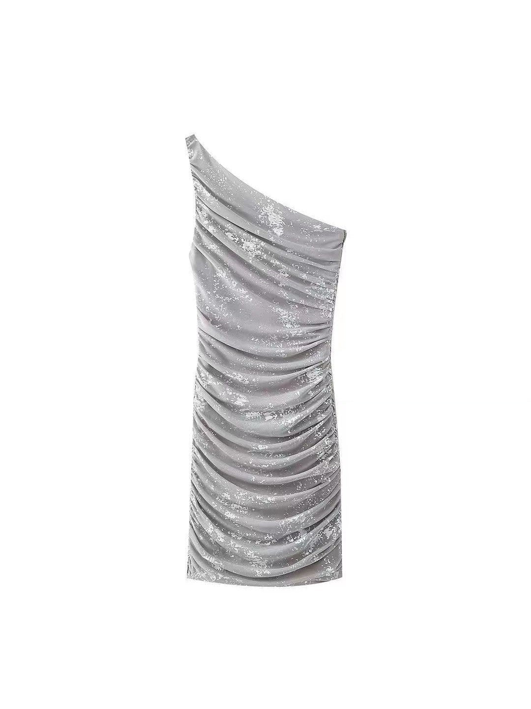 Metallic silver one-shoulder dress with ruched mesh tulle and a speckled pattern, form-fitting length.