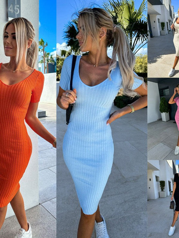 Blonde model in ribbed knit bodycon sweater dress in orange and light blue, V-neck, short sleeves, sneakers outdoors.