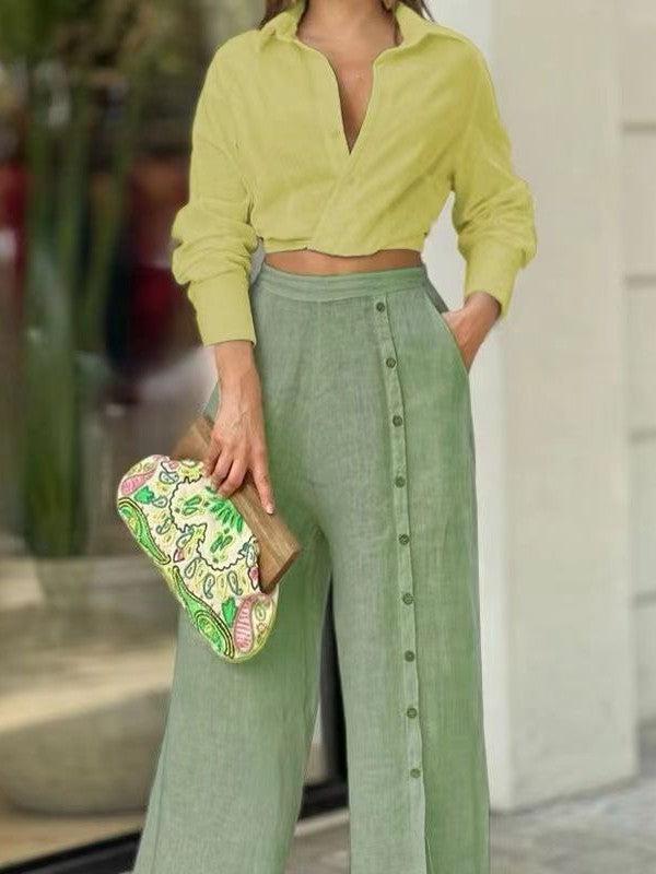 Lime cropped button-front top with collar and sage linen front-button pants. Woman holds a colorful paisley clutch.