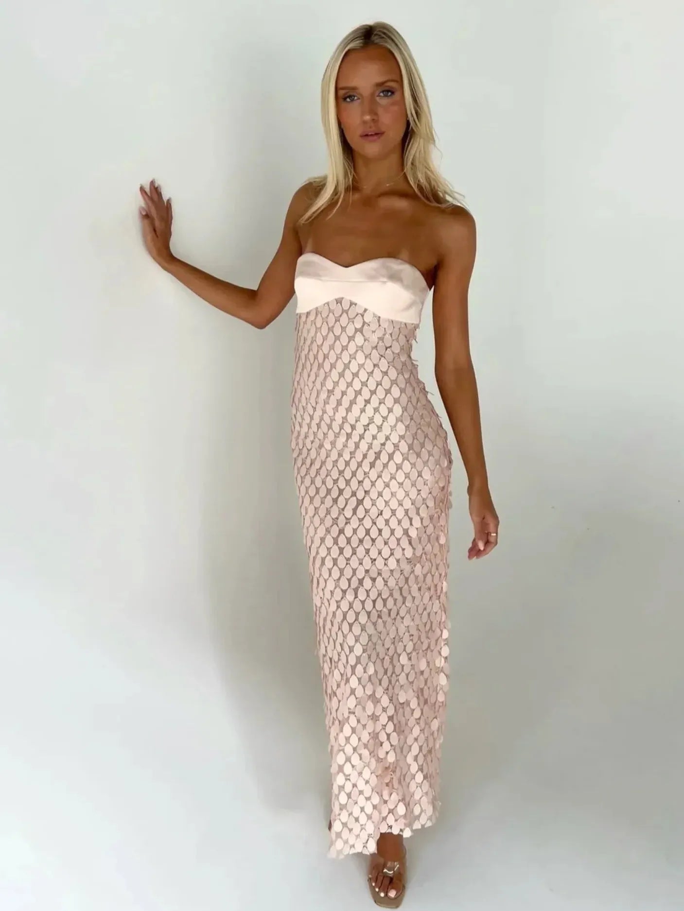Blush pink strapless tube maxi dress with satin bust and mermaid-scale sequin overlay.
