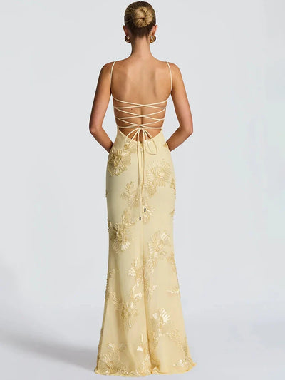 Back view of pale yellow floral jacquard mermaid maxi dress with spaghetti straps and a lace-up back with a bow.
